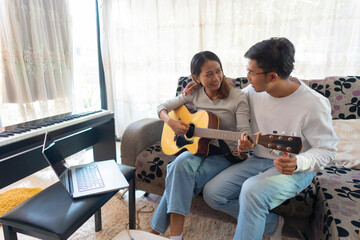 The couple is practicing playing a musical instrument.
