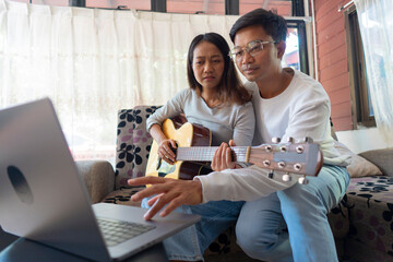 The couple is practicing playing a musical instrument.