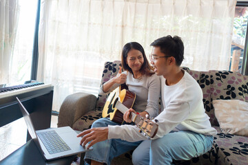 The couple is practicing playing a musical instrument.