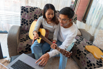 The couple is practicing playing a musical instrument.