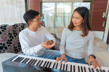 The couple is practicing playing a musical instrument.