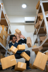 Warehouse worker losing balance as cardboard boxes fall from storage shelves