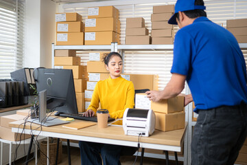 A female warehouse worker is receiving packages and verifying shipping information
