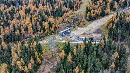 aerial landscape view of Kronplatz 1+2 middle station, situated on northern mountainside of Kronplatz (Plan de Corones) during autumn, with snowless ski slopes, cable car systems, buildings 