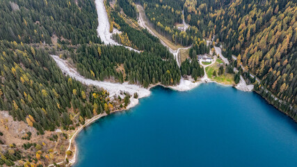 aerial view of landscape around northeast part of turquoise Antholzer See, a lake in the Antholzertal in South Tyrol, Italy, with Staller-Sattel-Pass St., "Enzianh&uuml;tte" and "Platzl am See" restaurant