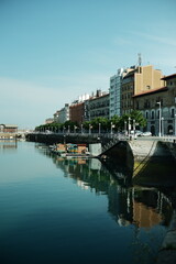 Gij&oacute;n city marina promenade with waterfront buildings in the old town. Coastal urban landscape with harbor water, seaside architecture and historic city atmosphere in northern Spain