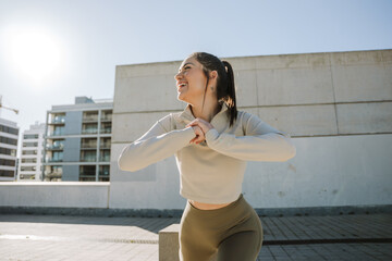 Woman lunges and laughs while holding hands together in front of her and looking away