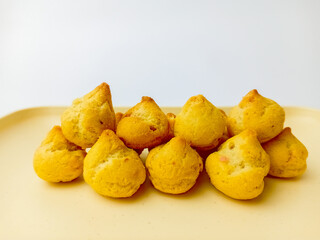 Mini choux with blueberry filling on a square plate. Isolated on white background. Delicious Snack.
