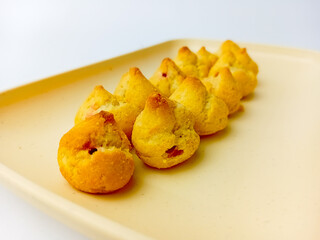 Mini choux with blueberry filling on a square plate. Isolated on white background. Delicious Snack.