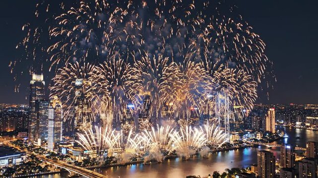 Epic aerial drone shot sweeping over a massive stylized metropolitan city skyline illuminated by hundreds of simultaneous colorful pyrotechnic firework bursts success concept, high angle, anniversary