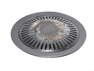 An overhead view presents a well-used, circular Korean BBQ grill with a metal design. The grill bears signs of repeated use.