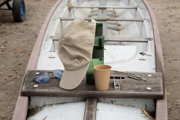 Active recreation on a boat. Thermos and cap on the boat deck, relaxation during yachting time. Wooden boat detail