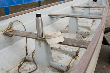 Active recreation on a boat. Thermos and cap on the boat deck, relaxation during yachting time. Wooden boat detail