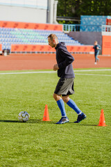 Obraz premium Male player running near cones after the ball