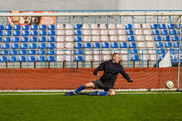 Goalkeeper falls for the ball near the goal