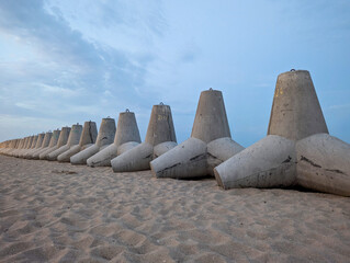 Reinforced tetrapods line the shore, protecting the beach from waves.