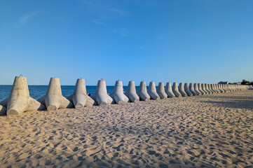 A long row of tetrapods stretches along the coastline.