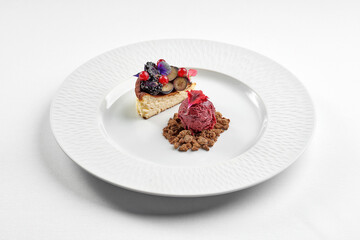 dessert featuring a slice of cheesecake topped with fresh mixed berries and edible flowers, served alongside a scoop of berry sorbet
