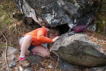 A girl is looking for a hidden treasure in the mountains. geocaching