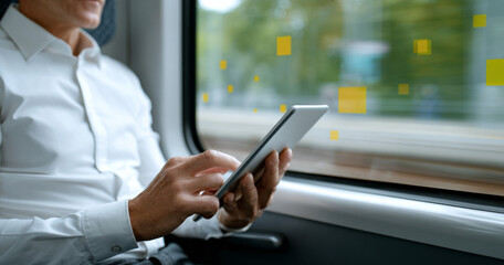 Man using digital tablet while traveling on train with blurred window background and digital data icons overlay