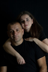 Fototapeta premium Couple embracing on black background symbolizing love and togetherness