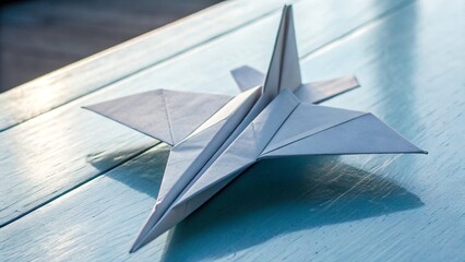 Close Up of Paper Origami Jet Airplane Isolated on Blue Pastel Background