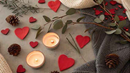 Valentine Flatlay Theme. Cozy warm flatlay featuring candles, red hearts, pinecones, and greenery, perfect for romantic atmosphere