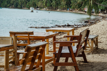 Tropical beach scene with beach loungers and palm trees. Beach with sun loungers casting long shadows on sand. Sun loungers and clear blue sky, perfect for relaxation.