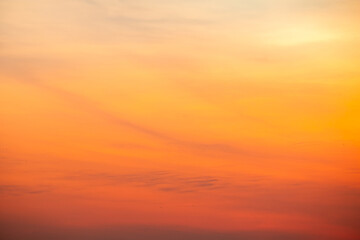 Obraz premium Sunset or sunrise sky with a vibrant gradient of orange, gold, and soft blue. Clear atmosphere with wispy clouds. Peaceful, natural light background. hope, freedom, new day and inspirational Concepts