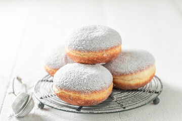 Sweet and fresh donuts with powdered sugar on cooling grate