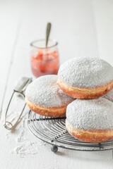 Sweet donuts with white icing on cooling grate