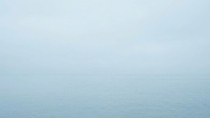 Misty Hazy Overcast Sky and Distant Raindrops Falling on Water Surface Calm Serene Atmosphere