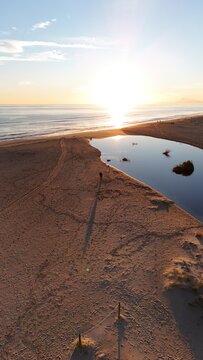 Primeras luces en un precioso amanecer en la playa mediterr&aacute;nea de Xeraco (Valencia), con la desembocadura del r&iacute;o al mar. 