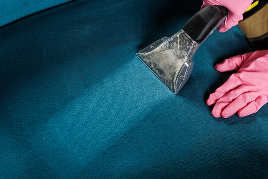 Upholstery steam extraction cleaning with vacuum nozzle and protective gloves