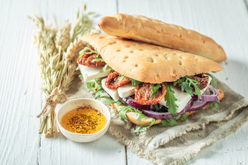 Delicious and fresh sandwich with arugula, cheese and dried tomatoes.
