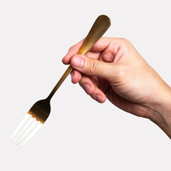 isolated of a man's hand holding a golden steel fork.