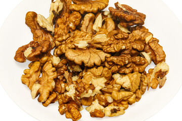 Shelled walnuts on a white plate displayed for a healthy snack or cooking ingredient