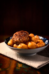 Fried meatballs with potatoes on a rustic background. Selective and soft focus.