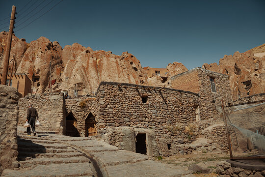 Traditional stone houses built into the rocky landscape of Kandovan village, Iran. The cave-like dwellings blend naturally with the surrounding mountains, showcasing ancient architecture and lifestyle