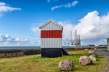 Seaside Hut With Red Stripe By The Sea And Offshore Oil Platform In The Background, Esbjerg, Denmark
