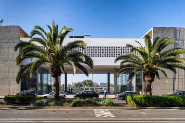 Modern Building Entrance With Palm Trees And Busy Street In Sunny Urban Setting, Agadir, Morocco