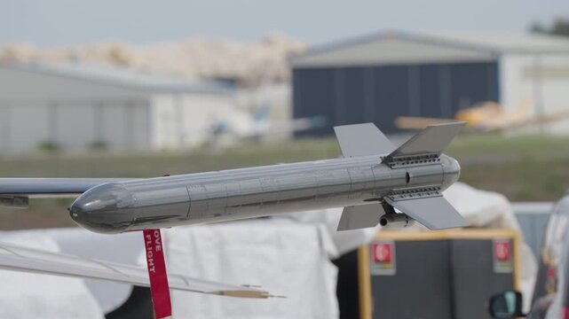 External auxiliary fuel tank mounted on underwing pylon of military transport aircraft with remove before flight streamer