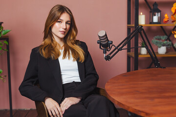 Podcast interview featuring a woman sitting at a desk with a microphone in a studio setting