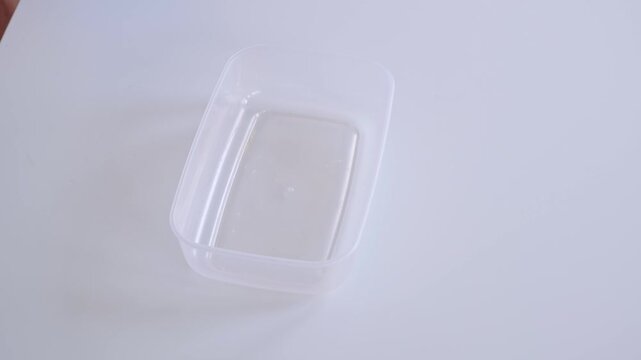 A man is opening the food container with a blue plastic lid. The concept of convenient unbreakable tableware. Reusable tableware for storage and freeze. High quality 4K footage.