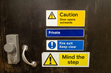 Warning signs on dark wooden door