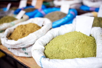 Colorful assortment of spices in burlap sacks displayed at a market, showcasing vibrant textures and earthy tones, inviting culinary exploration and flavor enhancement