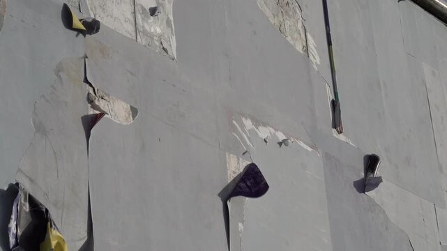 Peeling posters on a weathered wall reveal layered textures and colors. Urban decay and street art aesthetic.