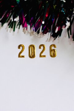 Multi coloured tinsel and 2026 on a white background