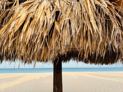 Close-up of a straw parasol on a sandy beach by the Caribbean Sea, Eagle Beach, Aruba