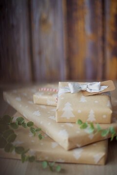 Close-up of a stack of Gift boxes wrapped in Christmas wrapping paper on a wooden table